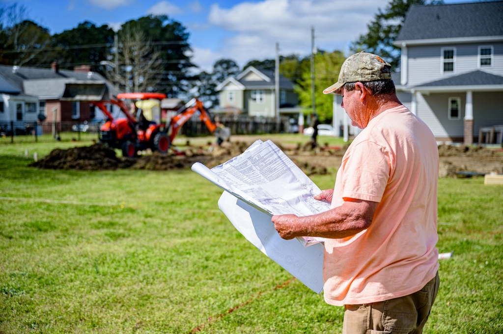 Founder reviewing plans on site
