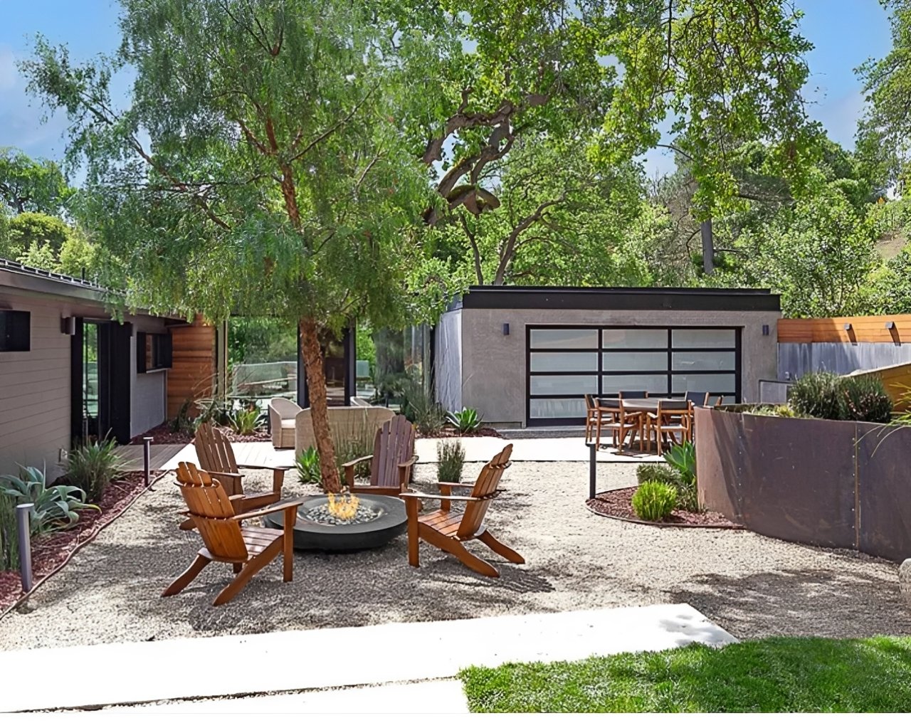 Gravel backyard with fire pit and Adirondack chairs